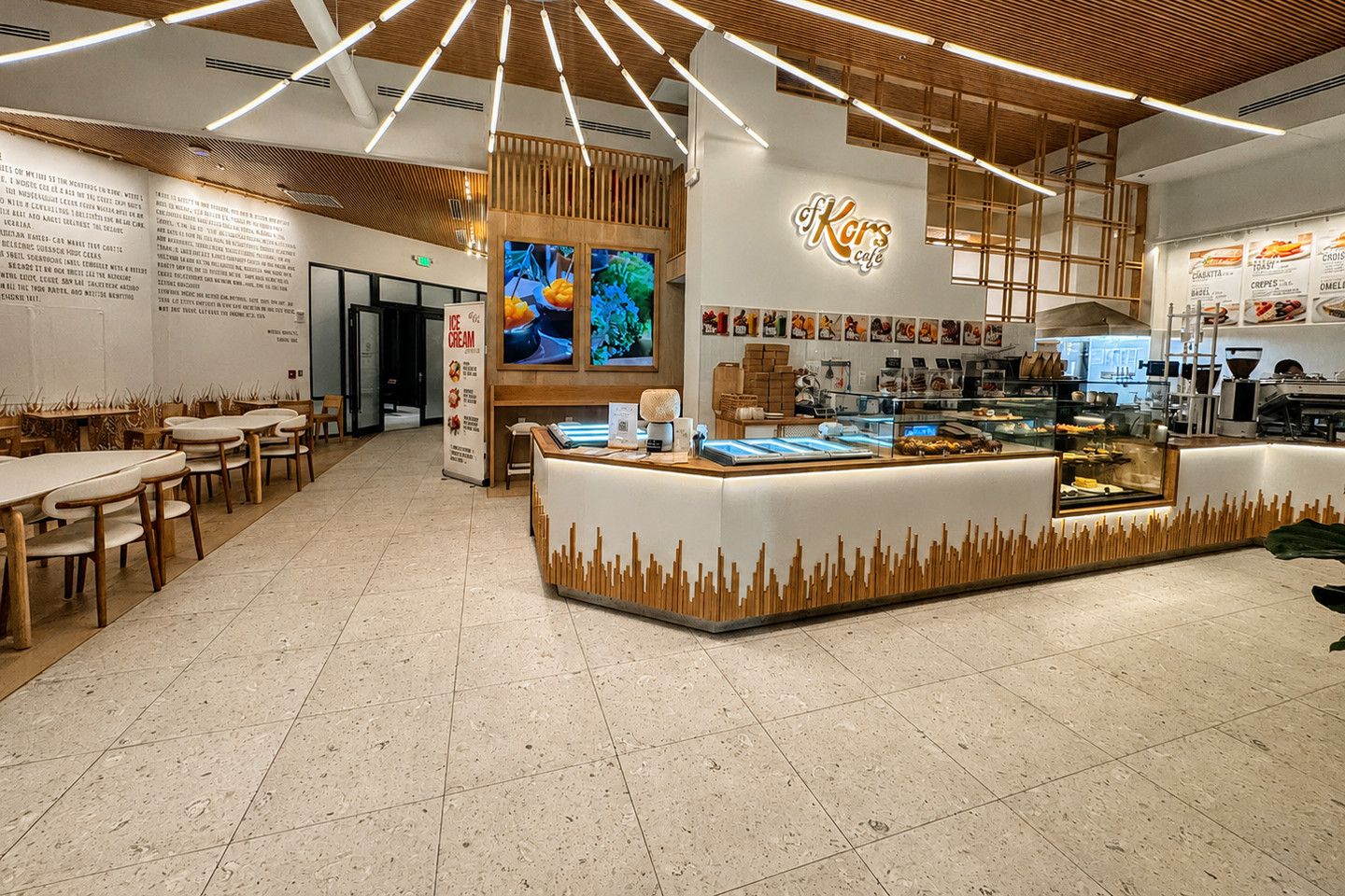 Cafรฉ with a long counter, seating and a light speckled tile floor
