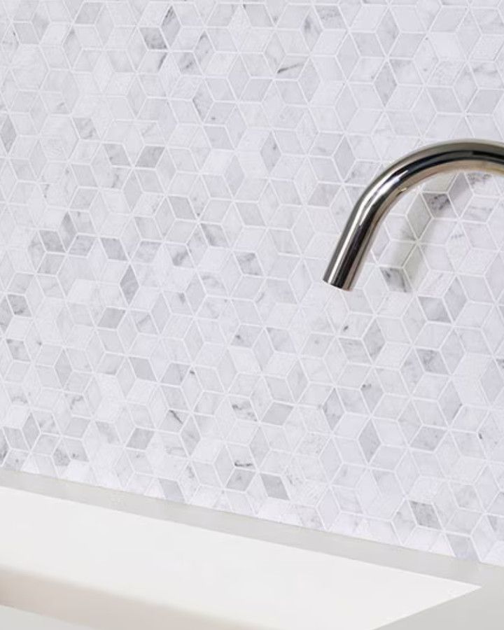 Gray and white diamond-pattern mosaic behind a sink and faucet
